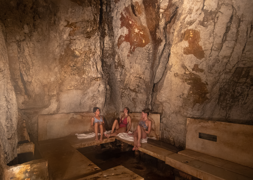 Women sit inside a spa treatment room inside a cave