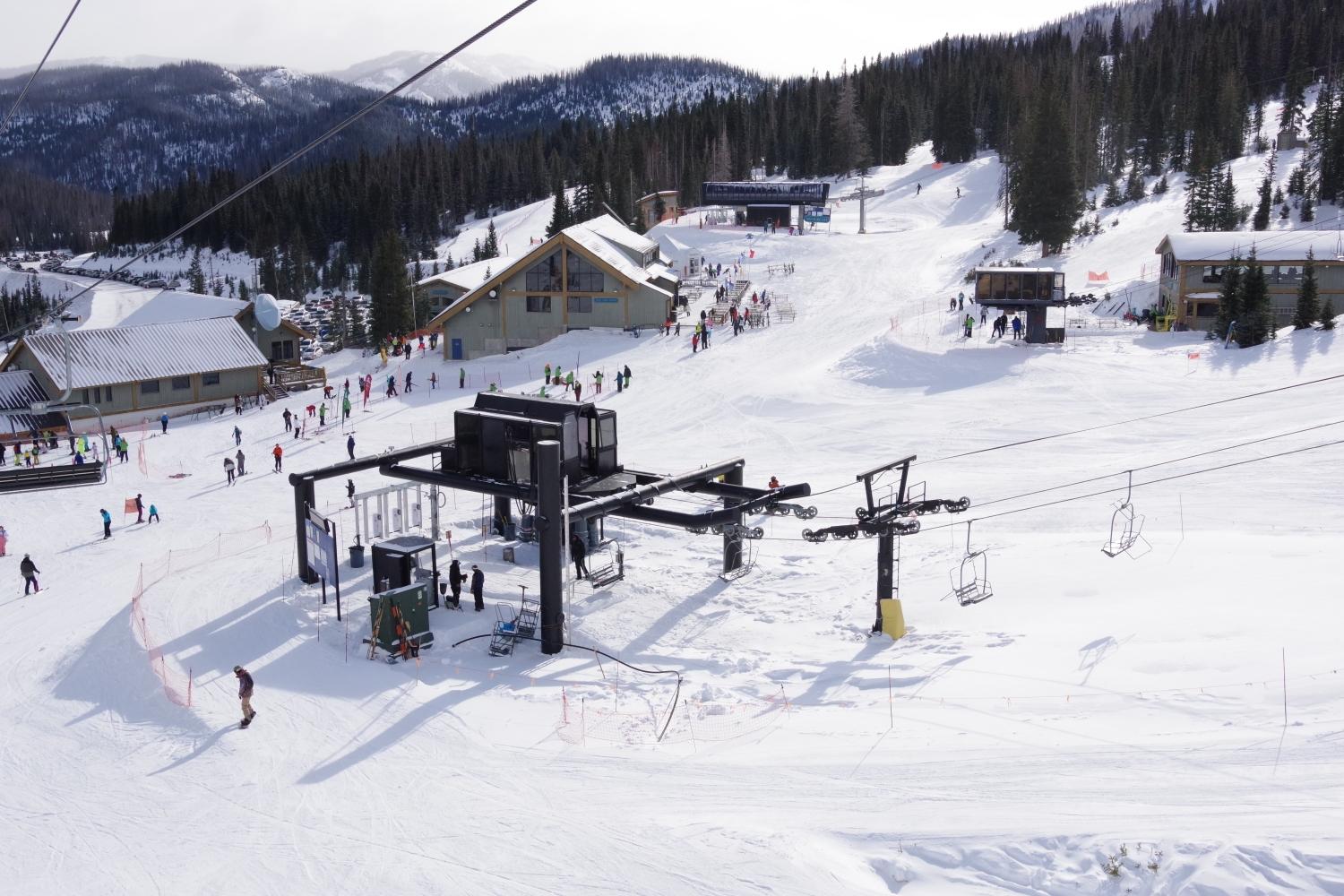 view of wolf creek's base area; specifically the bonanza lift with the nova and treasure lifts in the background as well as the main day lodge, wolf creek lodge. photo